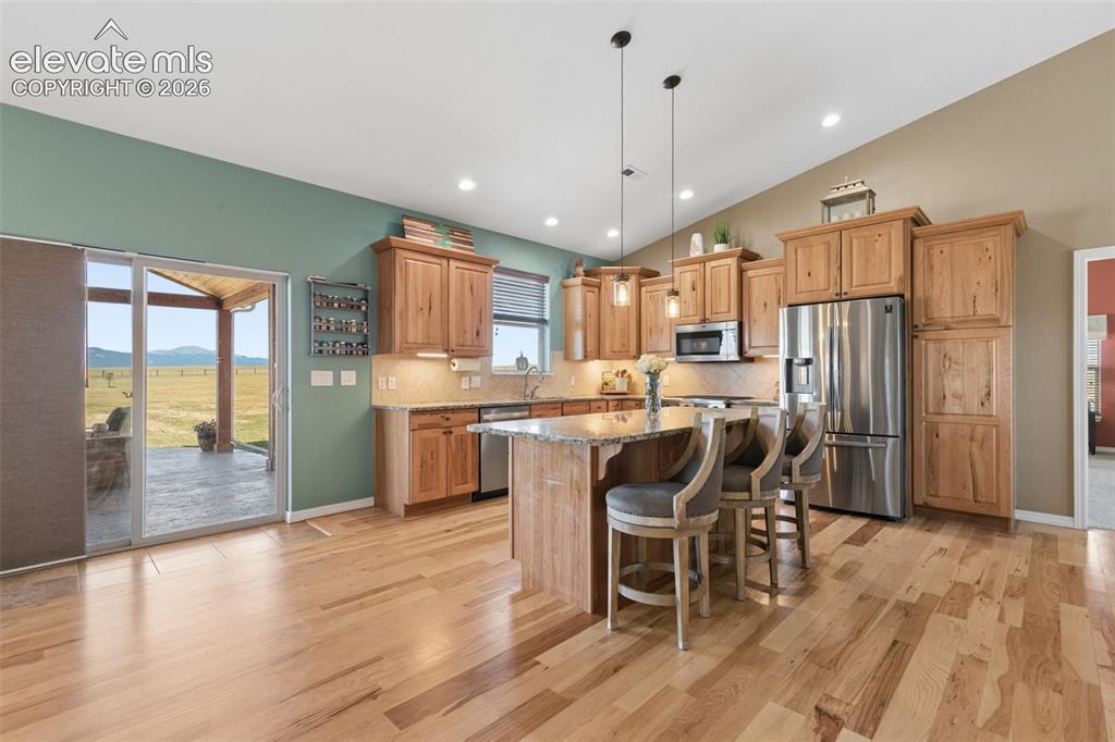 Image 11 of 48: Custom Hickory Cabinets and Walk-out Access to Covered Patio!