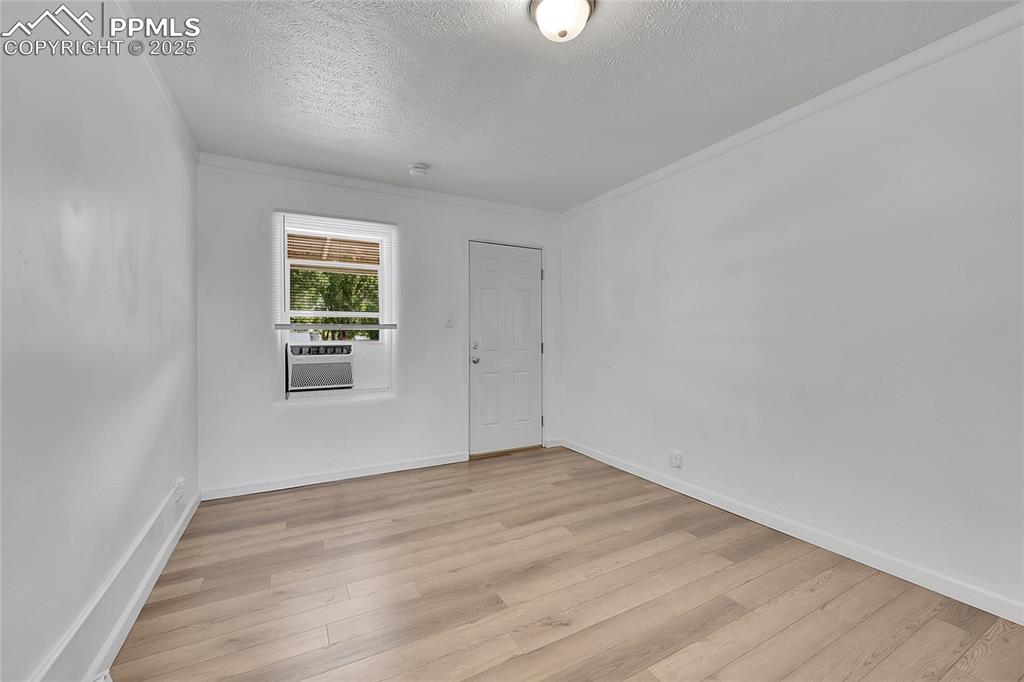 Image 12 of 32: Unfurnished room featuring light wood-type flooring, a textured ceiling, an