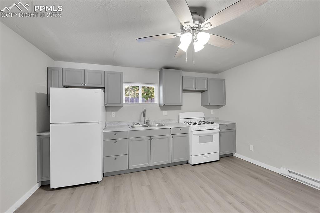 Image 16 of 32: Kitchen featuring white appliances, gray cabinets, light wood-style floors,