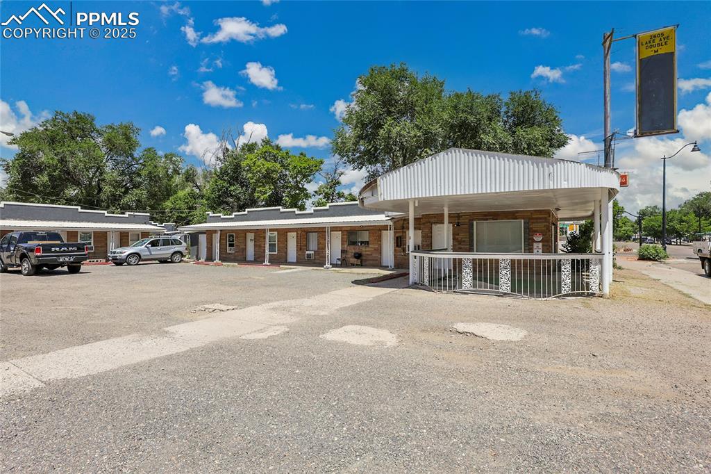 Image 2 of 32: View of front of home featuring a porch, uncovered parking, and brick sidin