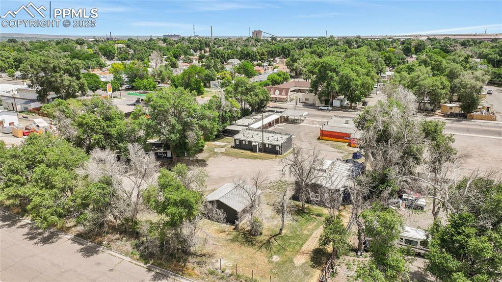 Image 28 of 32: Aerial view of residential area with a tree filled landscape