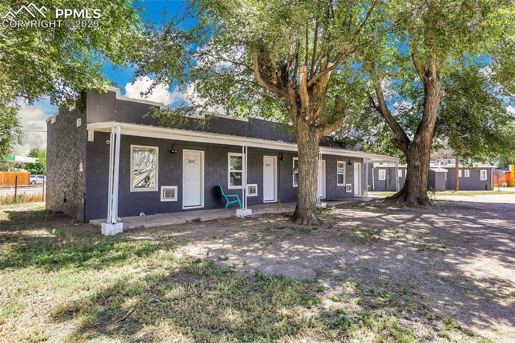 Image 7 of 32: View of front of home featuring stucco siding and covered porch