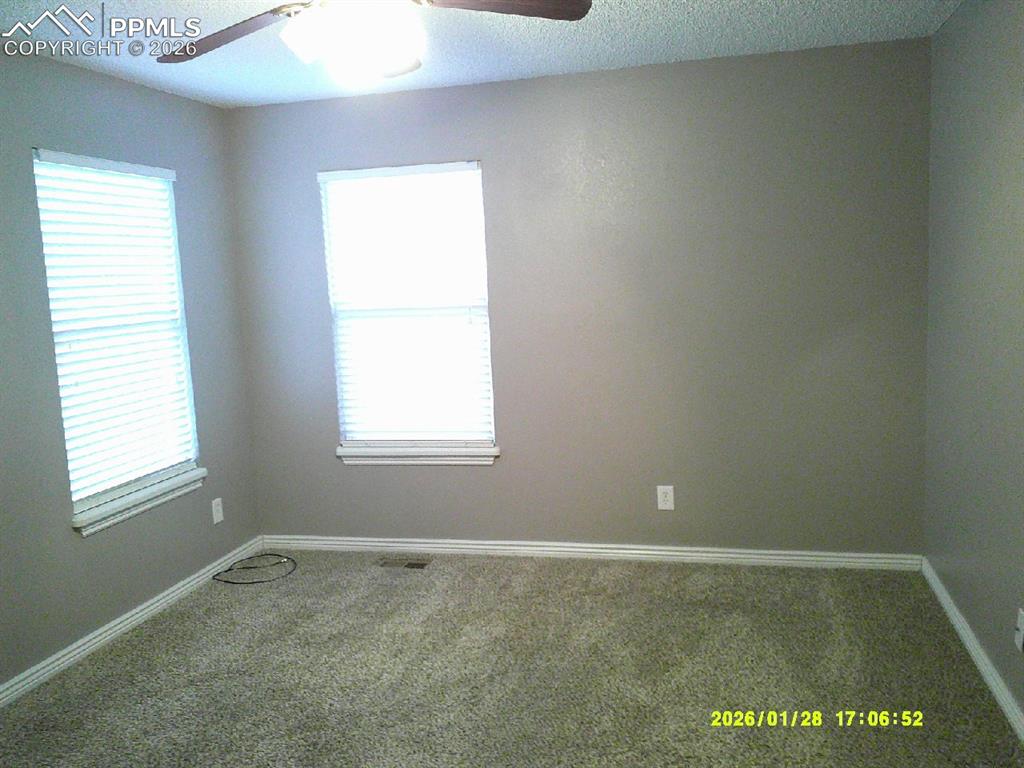 Image 11 of 22: Carpeted empty room featuring a ceiling fan and a textured ceiling