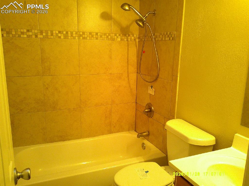 Image 12 of 22: Full bath with a textured wall, vanity, and washtub / shower combination