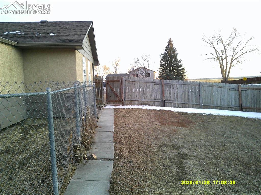 Image 16 of 22: Fenced backyard with a gate