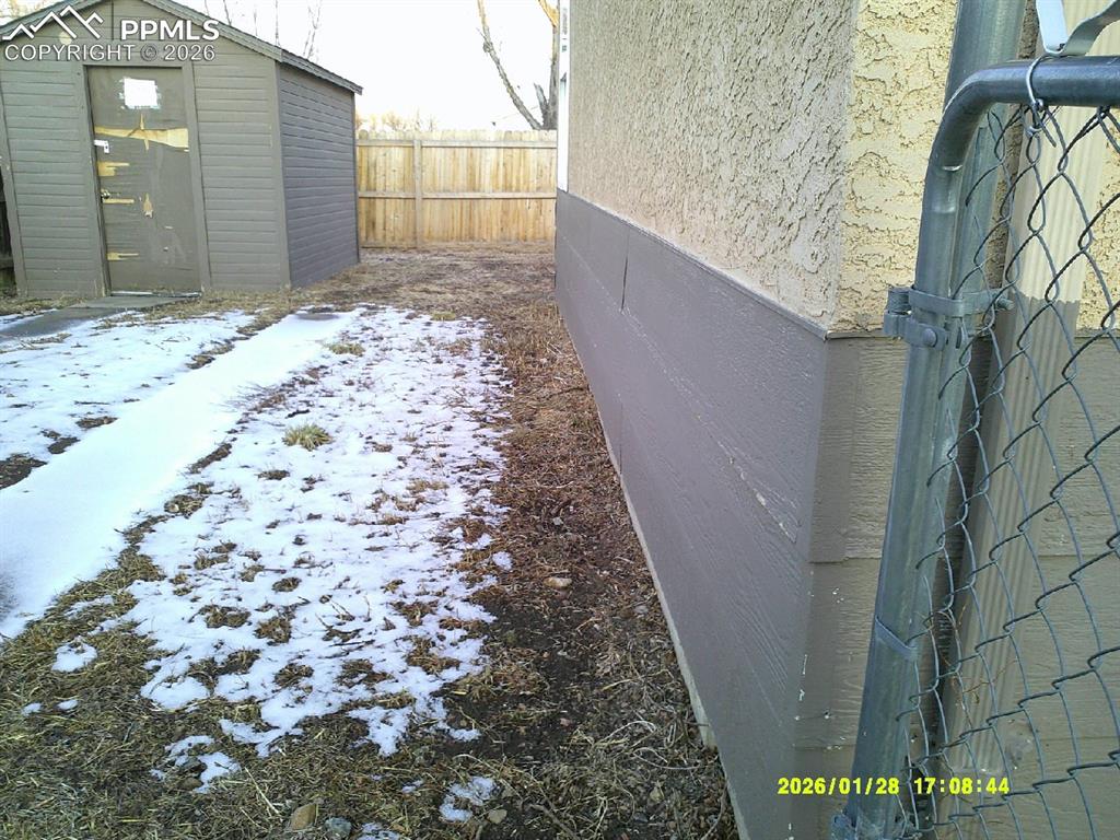 Image 17 of 22: View of side of property featuring a storage shed