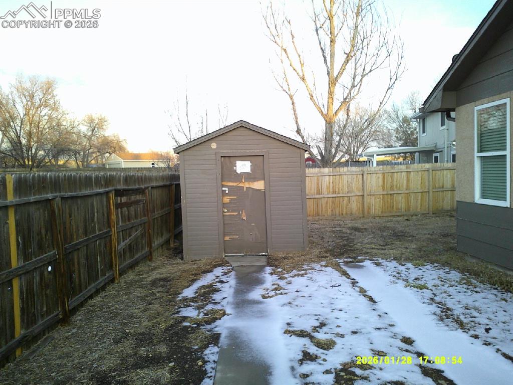 Image 19 of 22: View of shed with a fenced backyard