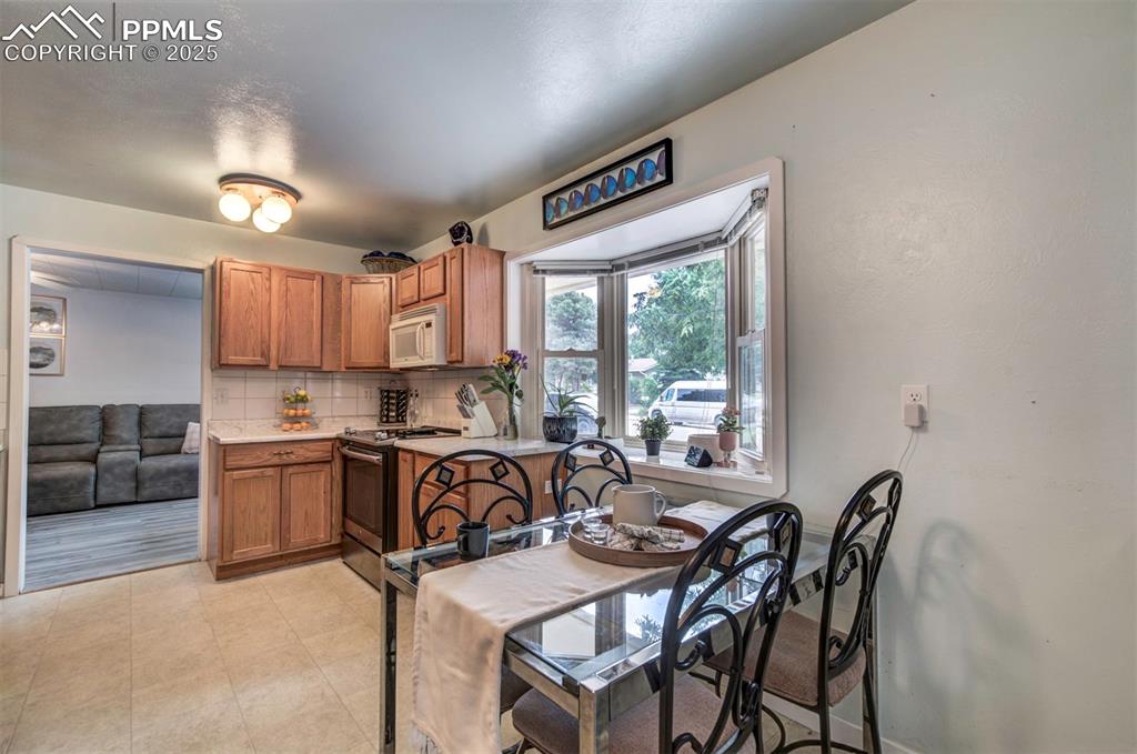 Image 11 of 32: Kitchen featuring decorative backsplash, stainless steel electric range ove