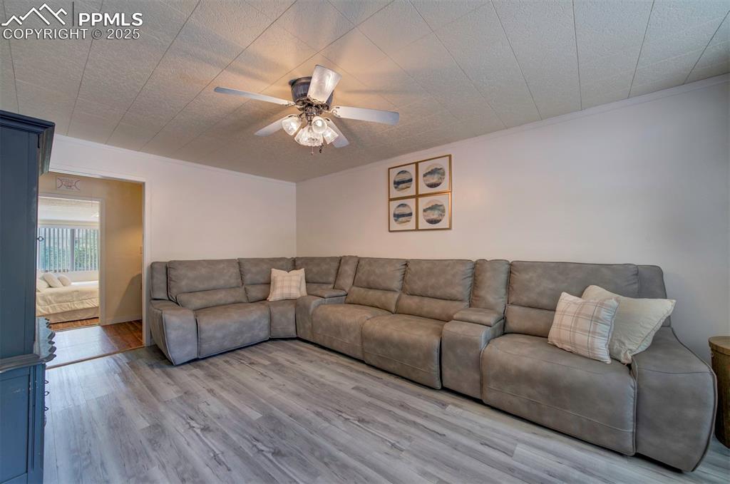 Image 12 of 32: Family area featuring wood-style floors, a ceiling fan and a textured ceili