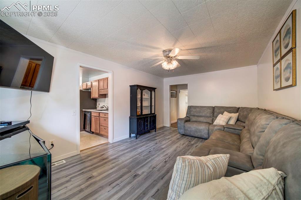 Image 13 of 32: Family room with a ceiling fan and wood style floors