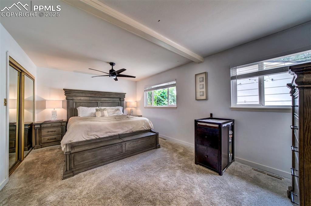 Image 15 of 32: Bedroom featuring carpet floors, beamed ceiling, walk in closet and ceiling