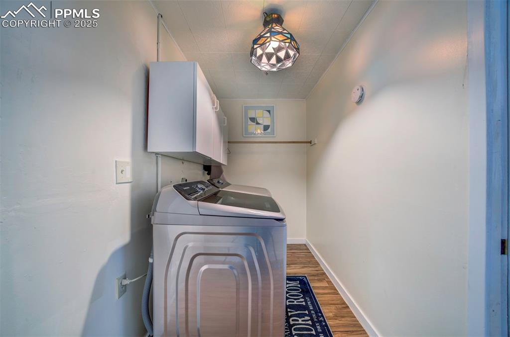 Image 27 of 32: Washroom with washer and dryer and wood style floors