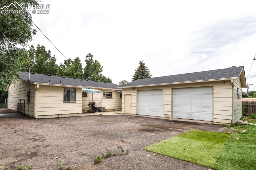 Image 32 of 32: featuring garage, awning, and back entrance