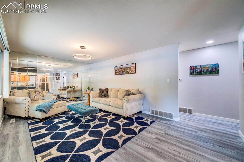 Image 6 of 32: Living area featuring mirror accent wall