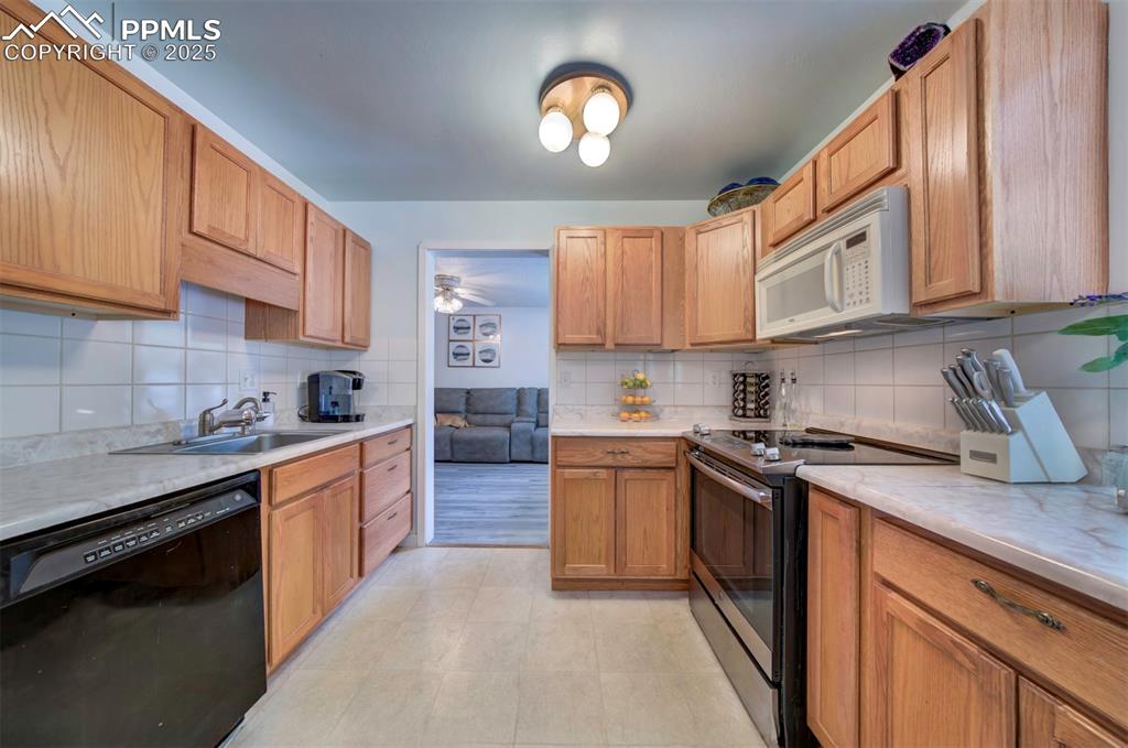 Image 9 of 32: Kitchen featuring stainless steel electric stove, black dishwasher, white m