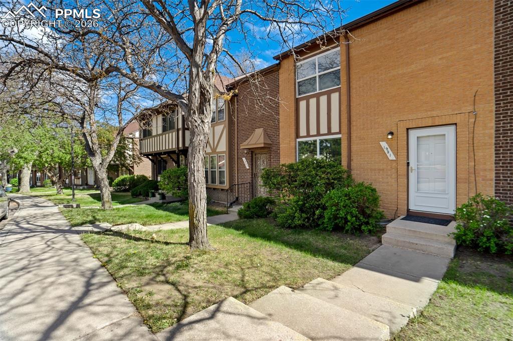 Image 1 of 49: Brick exterior featuring a white entry door with frosted glass, concrete st