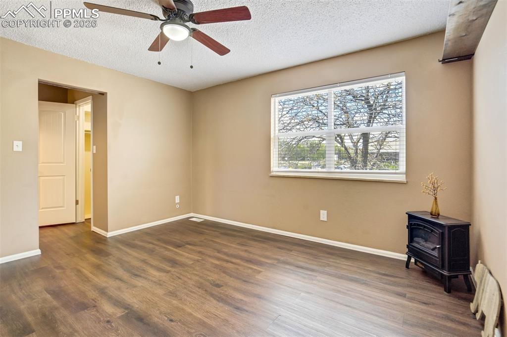 Image 16 of 49: Spacious room featuring wood-finish flooring, a ceiling fan with integrated