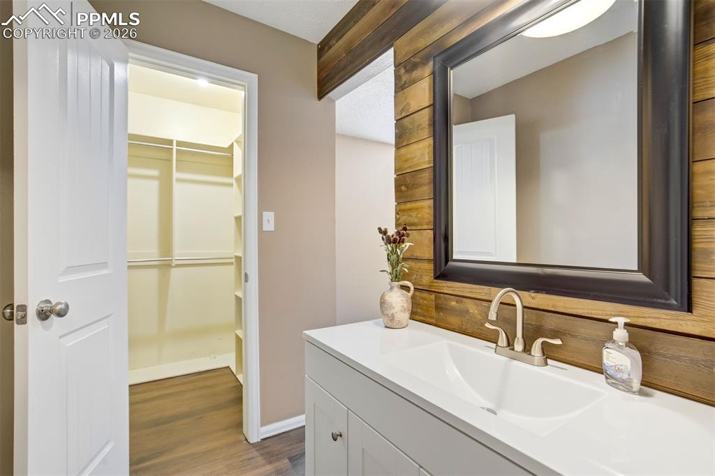 Image 18 of 49: Bathroom vanity featuring a single basin, brushed nickel faucet, and a larg