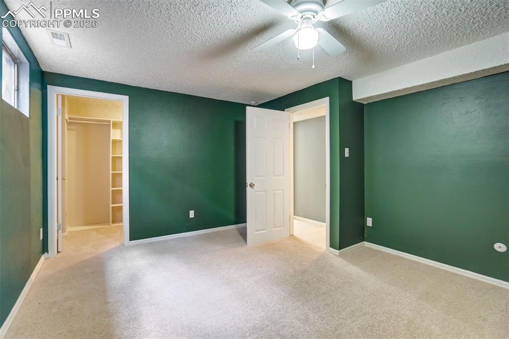 Image 30 of 49: Carpeted room featuring a ceiling fan with integrated lighting, a window, a