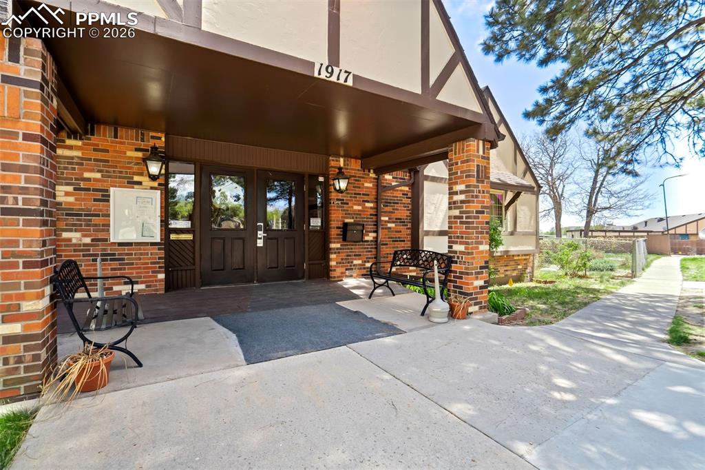 Image 45 of 49: Brick exterior with Tudor-style detailing and a covered entry