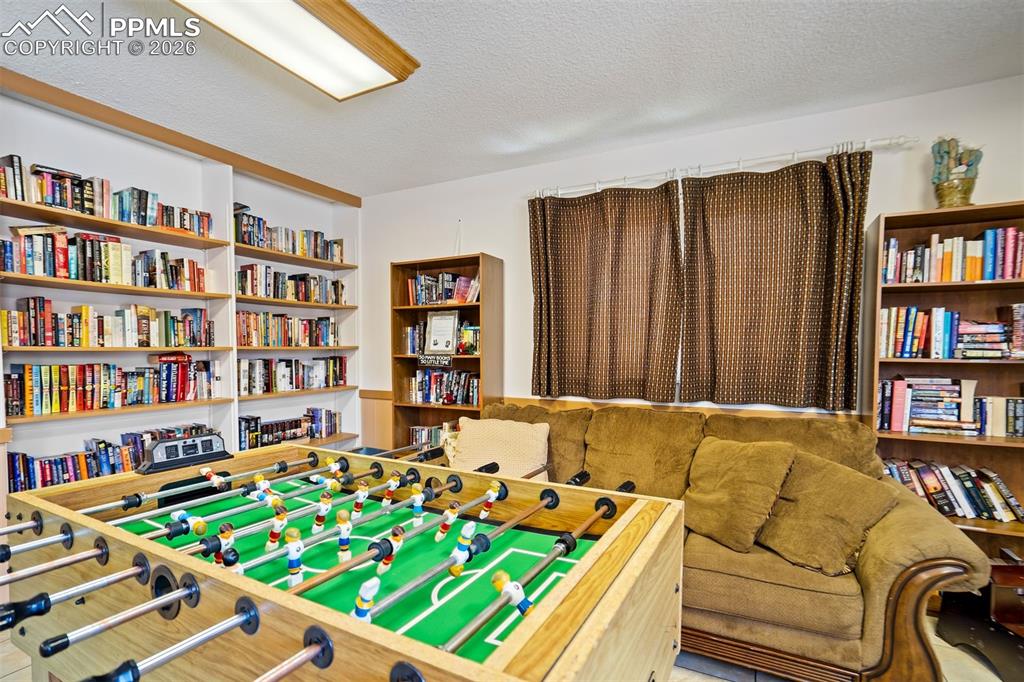 Image 48 of 49: Recreation room featuring a foosball table, extensive built-in shelving, ad
