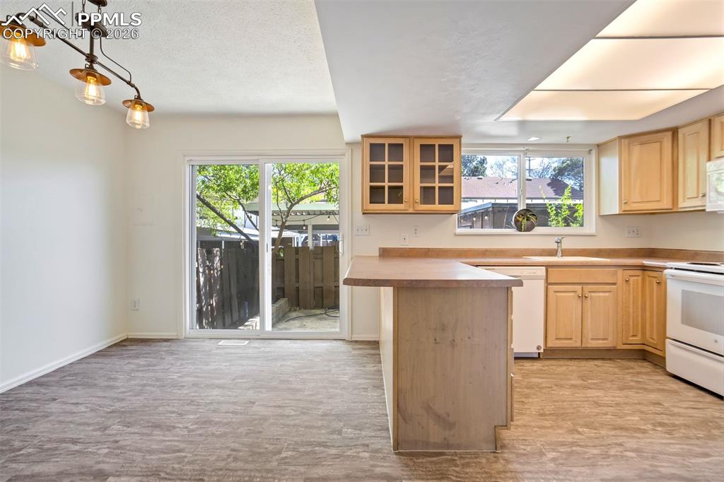 Image 7 of 49: Kitchen and dining area featuring wood-finish flooring