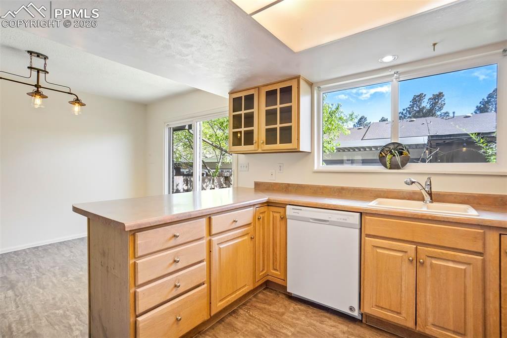 Image 9 of 49: Kitchen featuring wood-finish cabinetry, a peninsula with storage, and a bu