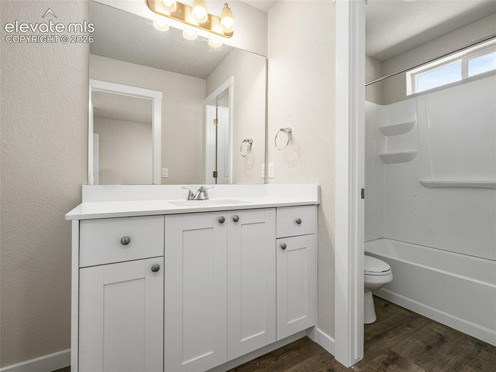 Image 6 of 30: Bright and functional bathroom featuring a white shaker-style vanity with m