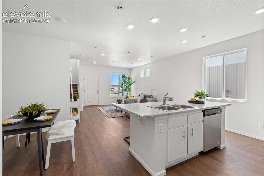 Image 15 of 30: Kitchen island with double basin sink, stainless steel dishwasher, and ligh