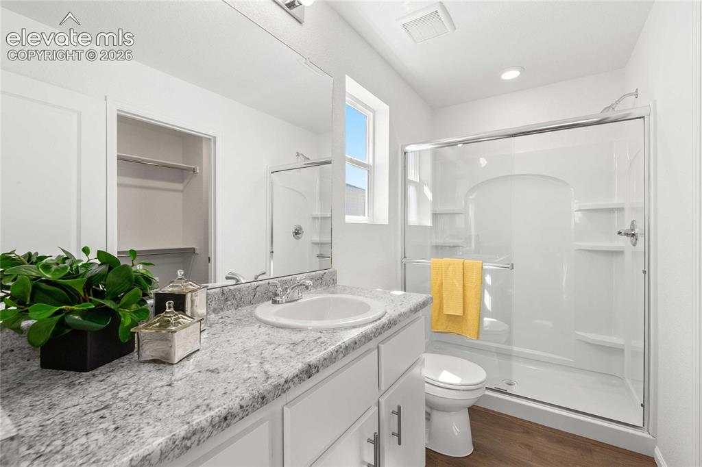 Image 18 of 30: White vanity with a single basin, granite-style countertop, and chrome fauc