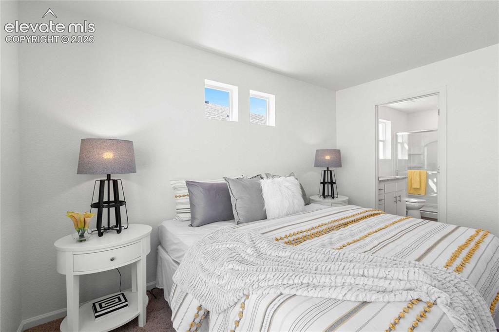 Image 19 of 30: Bedroom featuring high windows and an adjacent bathroom
*photos  of a mode