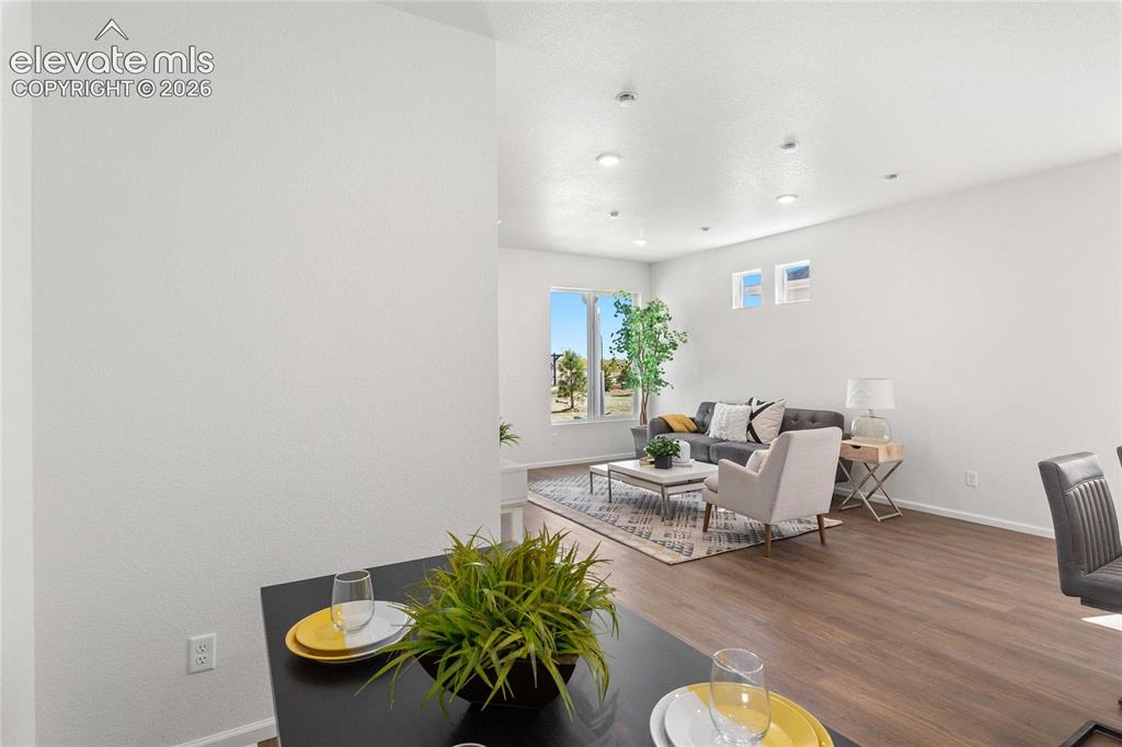 Image 2 of 30: Open-concept living area with wood-finish flooring, recessed lighting, and
