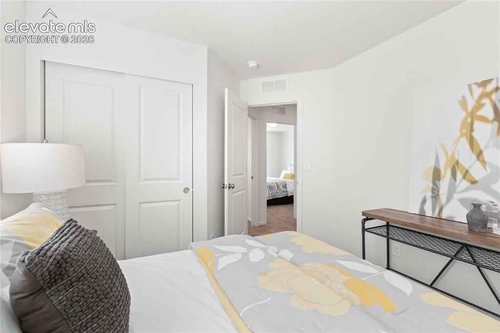 Image 23 of 30: White interior walls and ceiling, two-panel closet doors, and wood-finish f