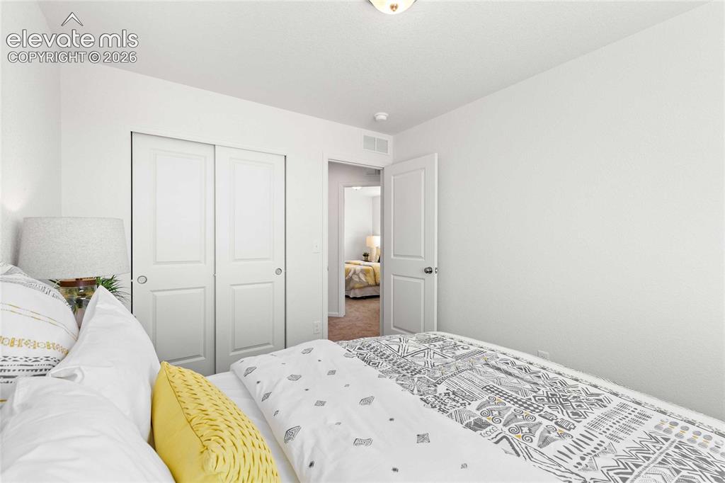 Image 25 of 30: White interior walls, two-panel sliding closet doors, ceiling light fixture