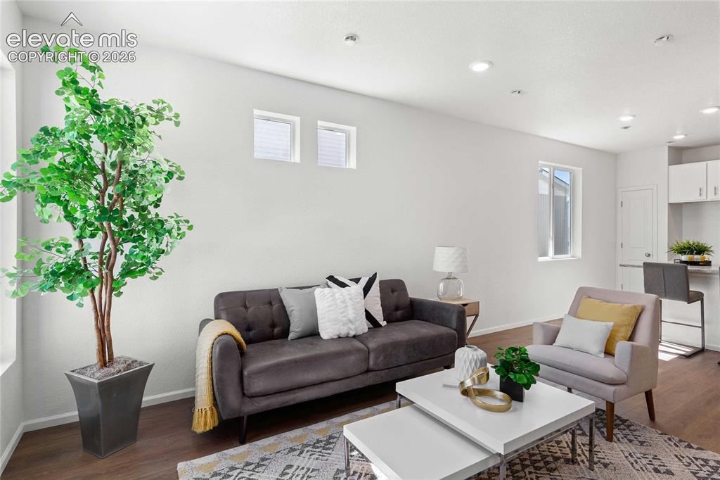 Image 5 of 30: Recessed ceiling lighting, wood-finish flooring, white walls, and white cab