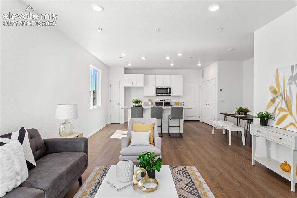 Image 6 of 30: Open-concept living space featuring wood-finish flooring, recessed lighting