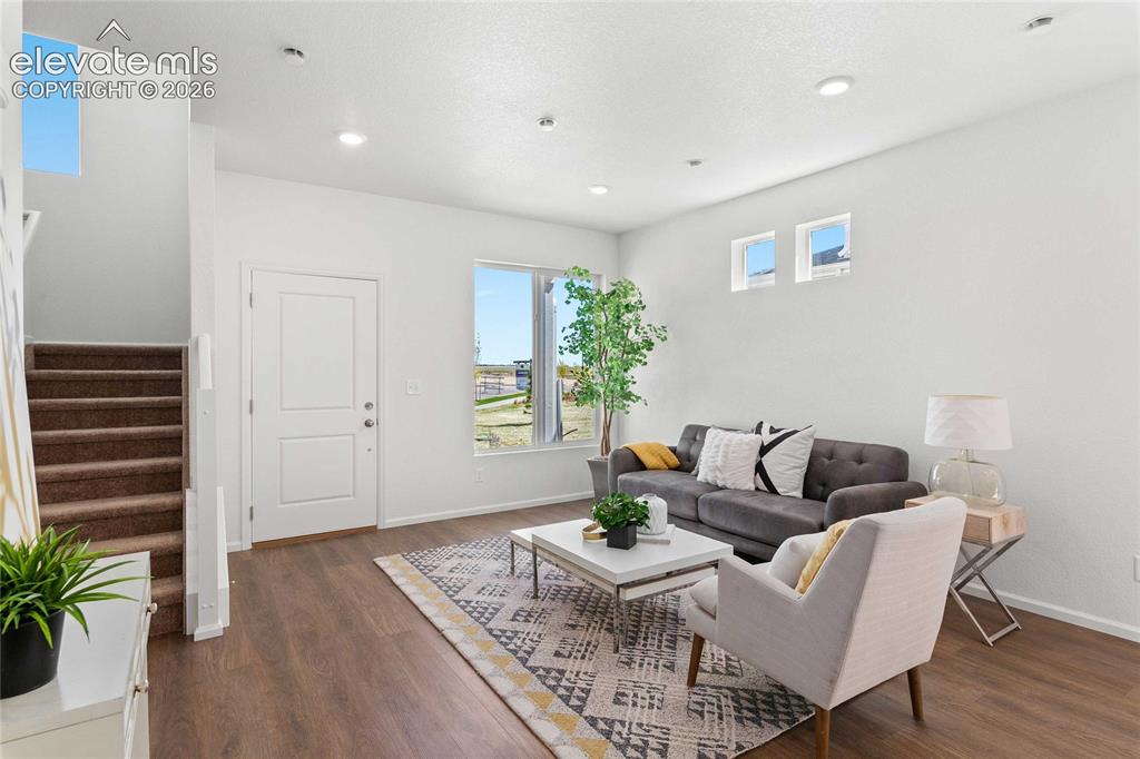 Image 8 of 30: Spacious living area featuring wood-finish flooring, recessed lighting, and