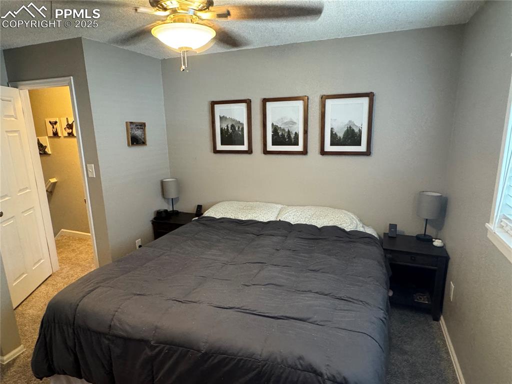 Image 10 of 40: Carpeted bedroom featuring a textured ceiling and a ceiling fan
