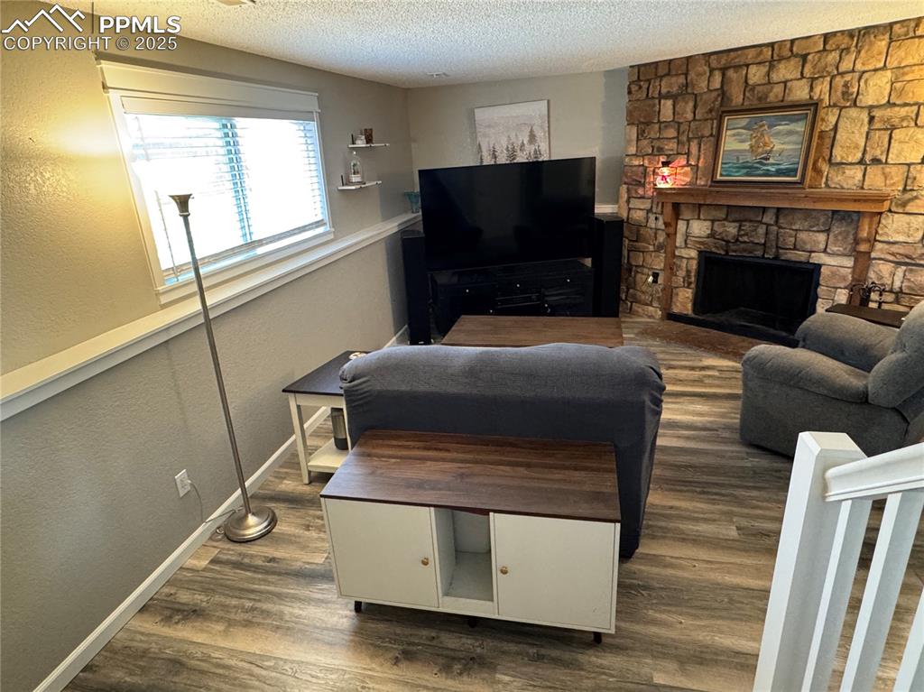 Image 18 of 40: Living area with a textured ceiling, a textured wall, dark wood-type floori
