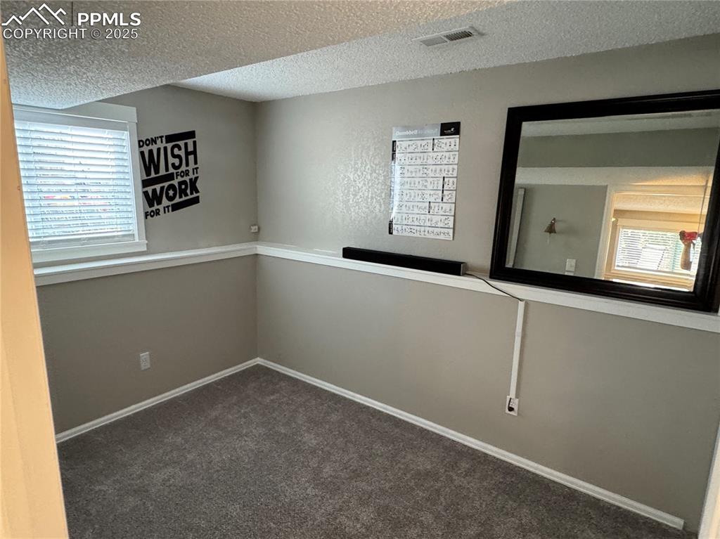 Image 21 of 40: Spare room featuring healthy amount of natural light, a textured ceiling, a