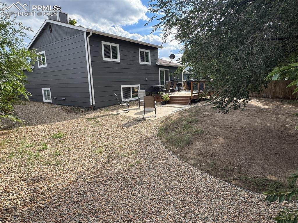 Image 26 of 40: Back of property with a wooden deck and a patio area