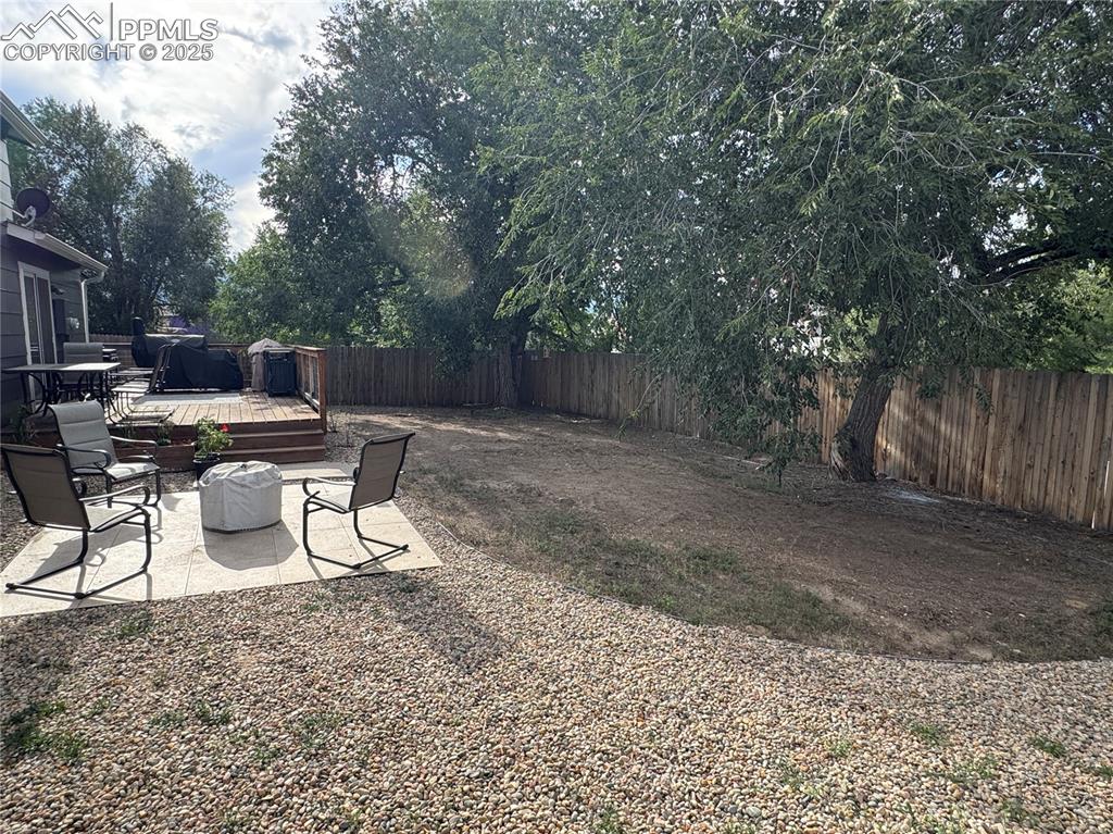 Image 27 of 40: Fenced backyard featuring a patio area and a deck