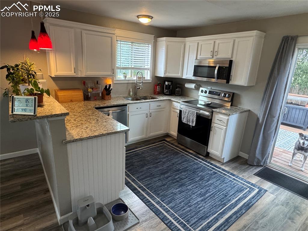 Image 6 of 40: Kitchen featuring white cabinetry, appliances with stainless steel finishes