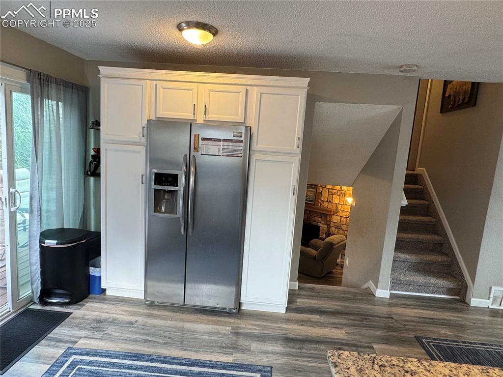 Image 8 of 40: Kitchen featuring stainless steel fridge with ice dispenser, a textured cei