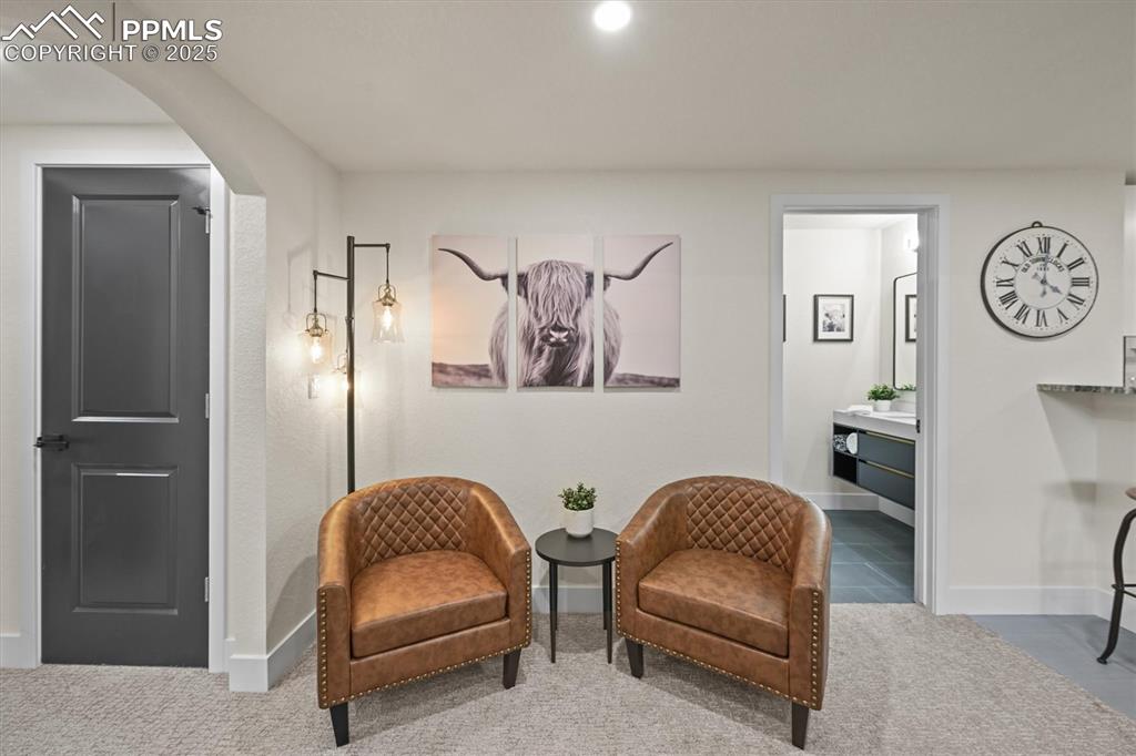 Image 23 of 47: Sitting room with carpet, arched walkways, recessed lighting, and tile patt