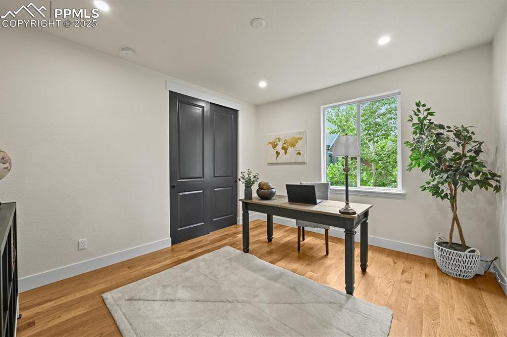 Image 32 of 47: Office space with light wood-style floors and recessed lighting