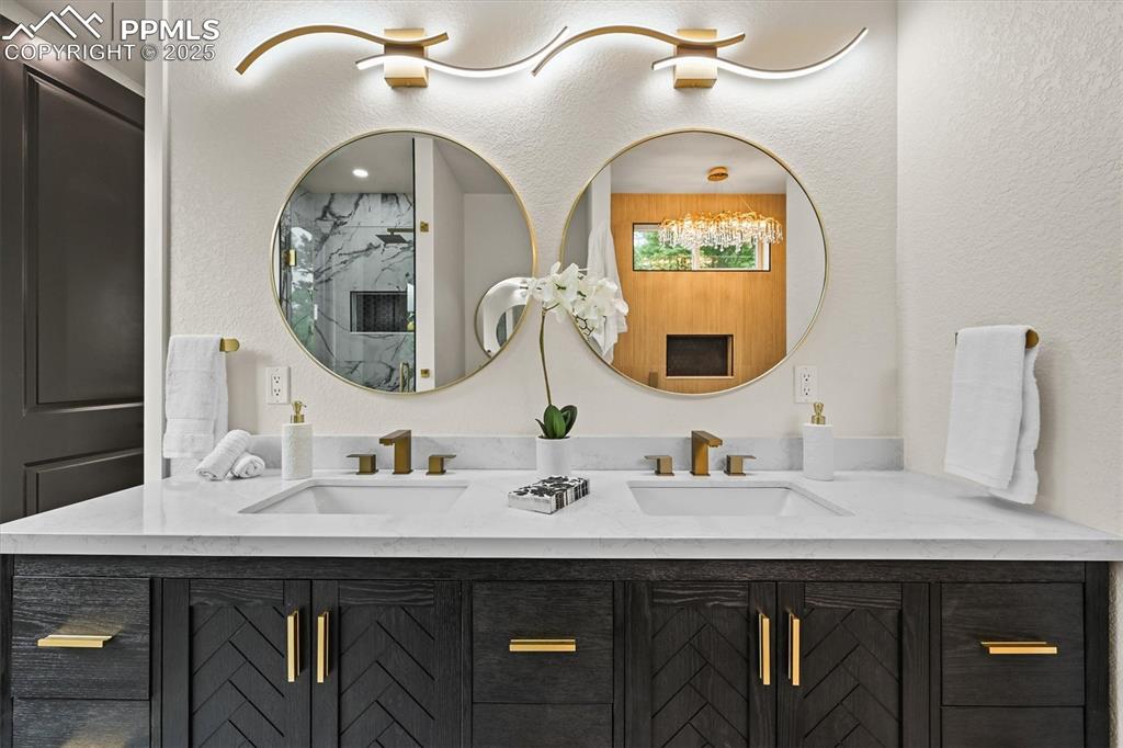 Image 35 of 47: Bathroom featuring a textured wall and double vanity