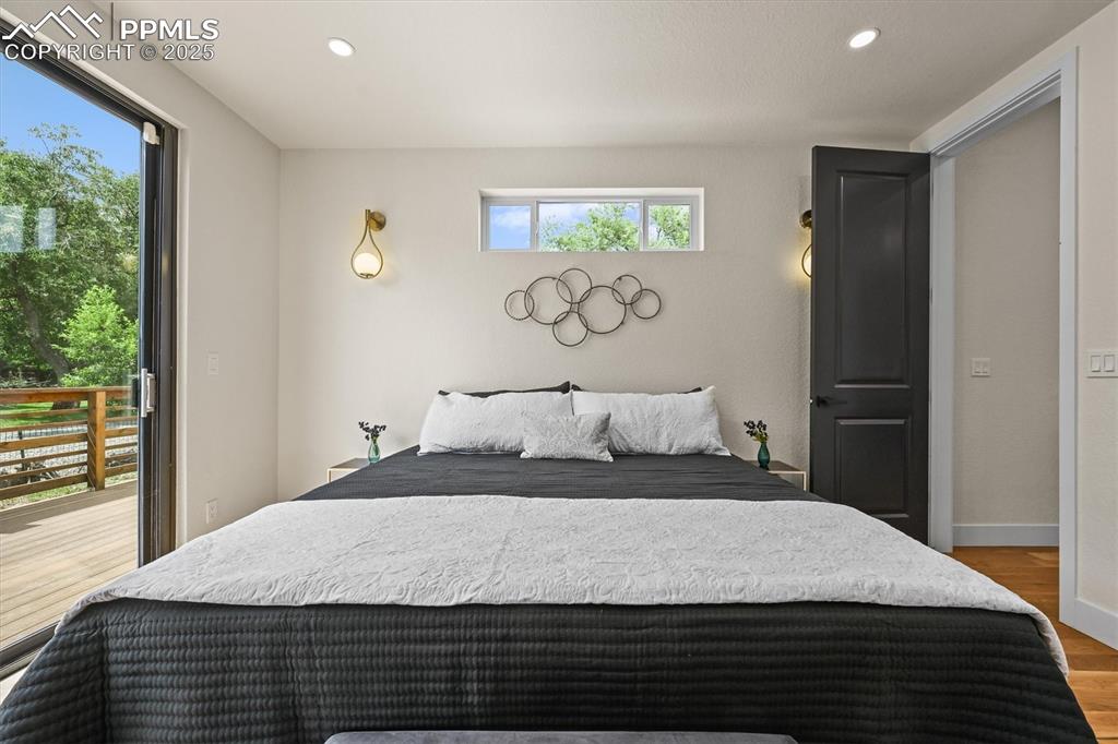 Image 38 of 47: Bedroom featuring wood finished floors, recessed lighting, and access to ou