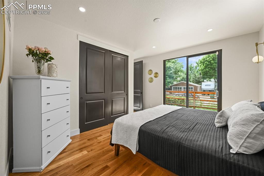 Image 39 of 47: Bedroom with light wood-style flooring, access to exterior, and recessed li