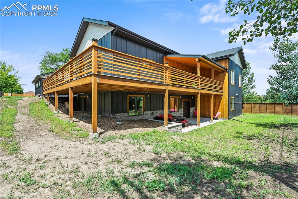 Image 45 of 47: Rear view of house featuring board and batten siding, a patio area, a deck,